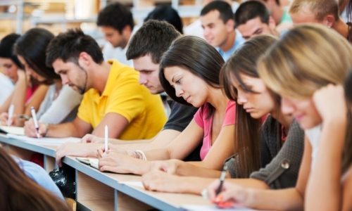 Large group of students writing.